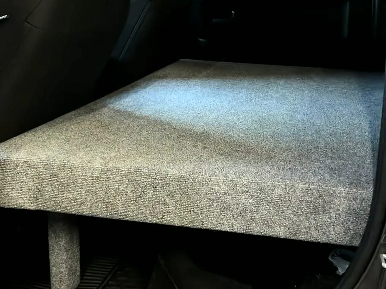 Custom carpeted storage and sleeping platform built into the crew cab
